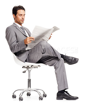 Buy stock photo A handsome young executive reading a newspaper while isolated on a white background