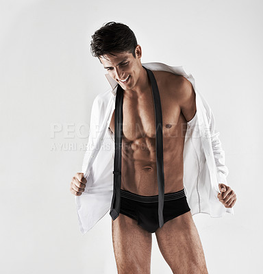 Buy stock photo Cropped shot of a handsome young man getting undressed