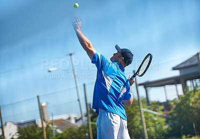 Buy stock photo A male tennis player tossing the ball up into the air for a service - Tennis