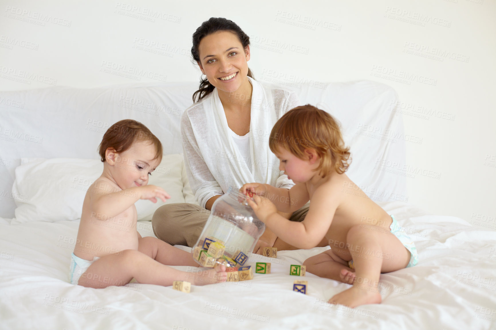 Buy stock photo Happy, toys and portrait of mother with babies on the bed playing for child development at home. Smile, love and young mom with wooden building blocks for learning with kids in bedroom at house.