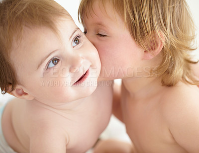 Buy stock photo Closeup of a sweet little girl giving her baby sister a kiss on the cheek