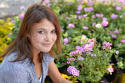 Buy stock photo A pretty mature woman sitting among her garden's many blooms
