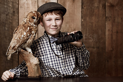 Buy stock photo Young boy in retro clothing wearing spectacles holding binoculars alongside an  owl