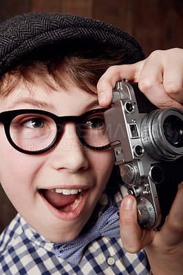 Buy stock photo Young boy in retro clothing wearing spectacles and holding up his camera