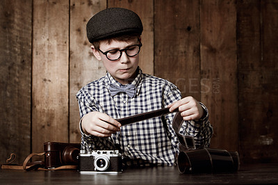Buy stock photo Photography, child and vintage with camera film, thinking and mockup in glasses by backdrop. Boy, idea and nerd with retro negative photos for pictures and eyewear for creative kids with inspection