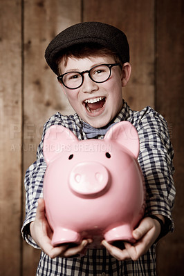Buy stock photo Young boy, piggy bank and happy in portrait for excited, money saving and cash savings in youth with retro fashion. Child, smile and face for coin banking and safe for bills with glasses by backdrop