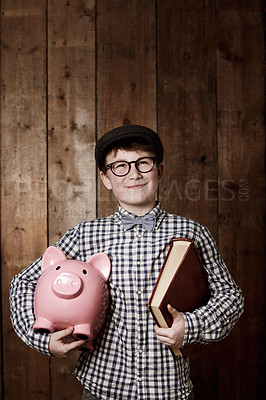 Buy stock photo Child, piggy bank or book in thinking for education, studio background or savings for finance lesson in youth. Boy, smile and plan in coin banking of investment and learning in retro glasses fashion