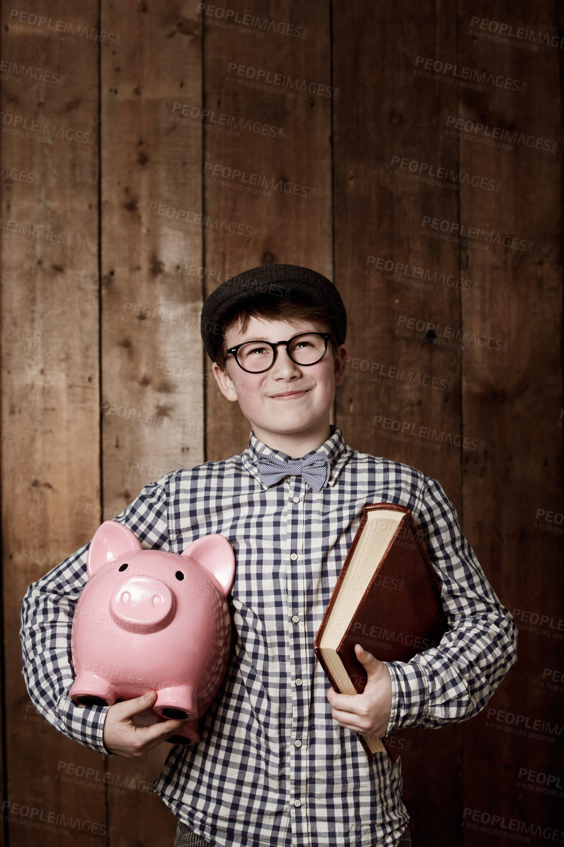 Buy stock photo Child, piggy bank or book in thinking for education, studio background or savings for finance lesson in youth. Boy, smile and plan in coin banking of investment and learning in retro glasses fashion