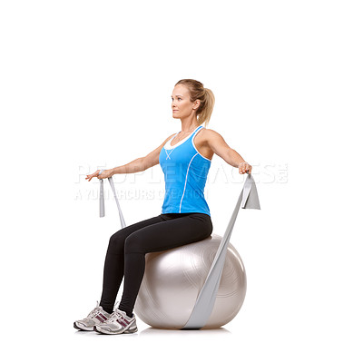 Buy stock photo A young blonde woman sitting on an exercise ball while pulling a resistance band - profile