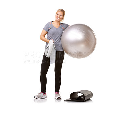 Buy stock photo A young woman holding a resistance band and an exercise ball standing next to her mat