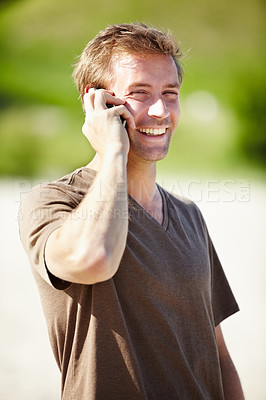 Buy stock photo A handsome young man talking on his cellphone and laughing