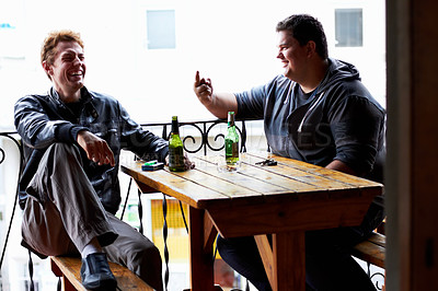 Buy stock photo Men, friends laugh and drinking beer at a pub and restaurant with conversation and discussion. Alcohol, guys and young people together at diner with alcohol and drink with bottle and joke at table