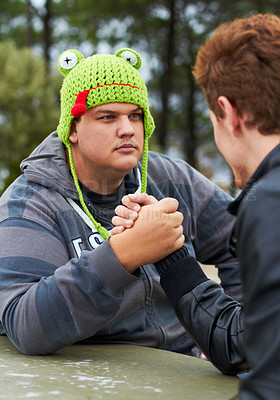 Buy stock photo Arm wrestling, friends and outdoor at table for sports, challenge and exercise. Strong, conflict and men holding hands for competition, serious power and muscle match, training or workout in park.