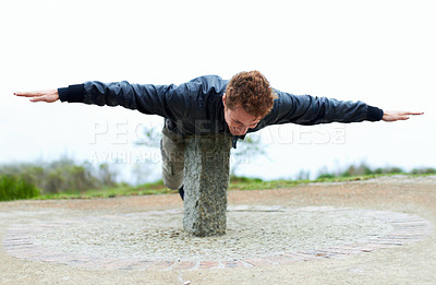 Buy stock photo Freedom, balance and a man on a cement block outdoor in nature for travel, vacation or adventure. Holiday, fun and the arms of a happy young person feeling carefree of cheerful in the afternoon