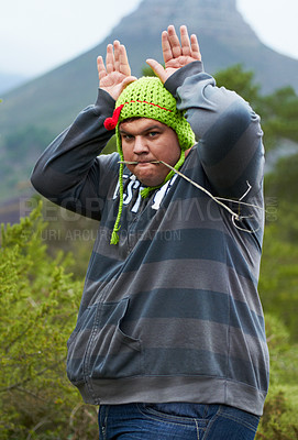 Buy stock photo Mountain, funny hat and portrait of man in nature for camping, hiking and adventure outdoors. Comic, humor and person with bunny ears for joke on holiday, vacation and explore to travel wilderness