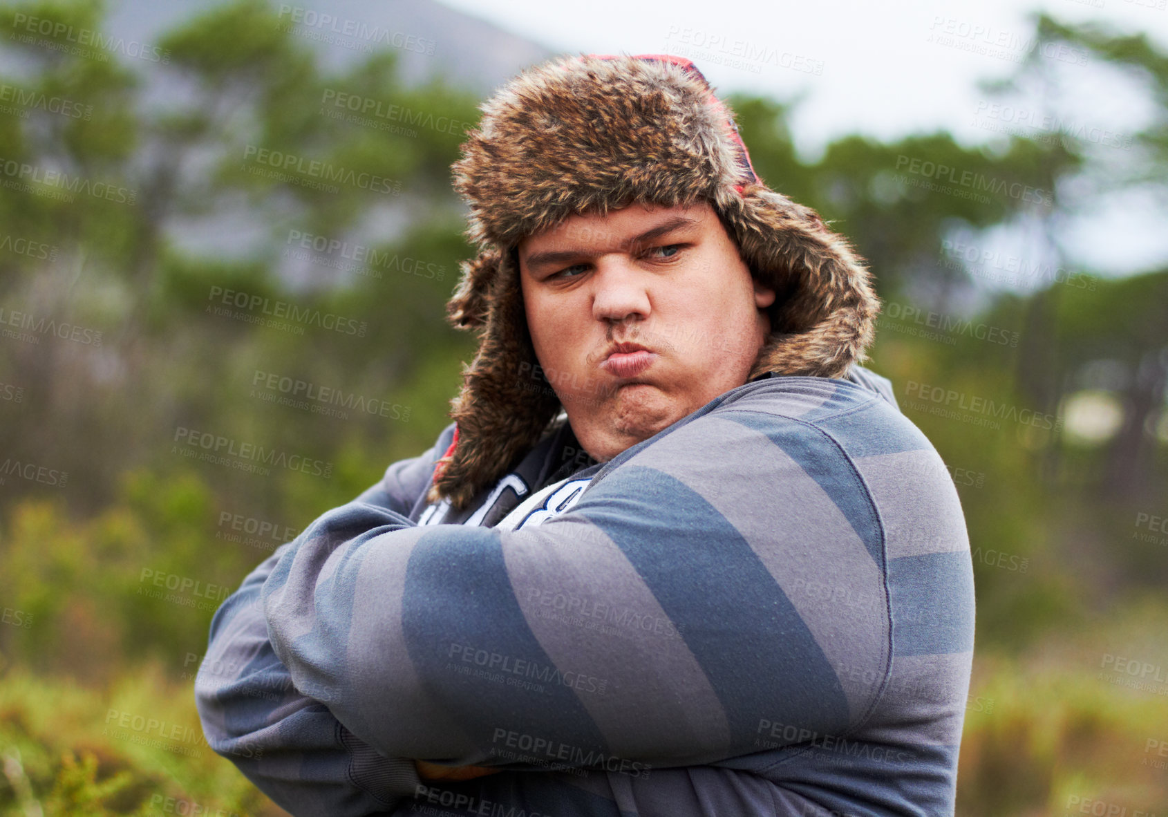 Buy stock photo Angry, frustrated and young overweight man in nature during winter unhappy, grumpy and sad due to outdoor problem. Anger, obesity and person with stress arms crossed and fail walking in a forest