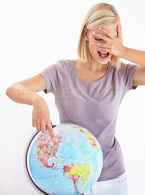 Buy stock photo Wow, guess or pointing and a woman with a globe in studio on a white background for destination choice. World, planet and hand gesture to a location on earth for overseas travel decision or selection