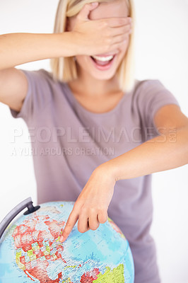 Buy stock photo Globe, hand and pointing with a woman tourist in studio on a white background for travel destination choice. World, atlas or random selection and a person covering her eyes for location decision