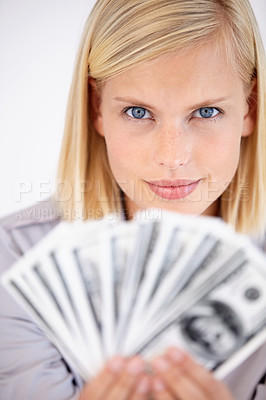 Buy stock photo A woman holding up a wad of cash with a challenging look in her eyes