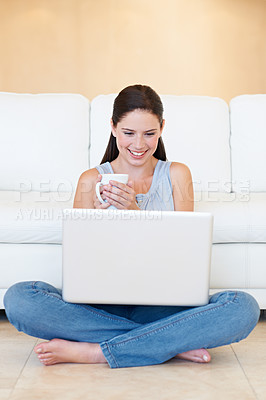 Buy stock photo A thoughtful young beauty with a laptop in her lap enjoying a cup of coffee