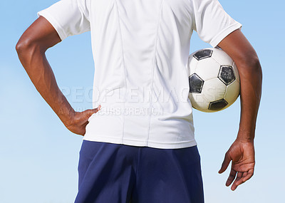 Buy stock photo Cropped rearview of a young man holding a soccer ball under his arms