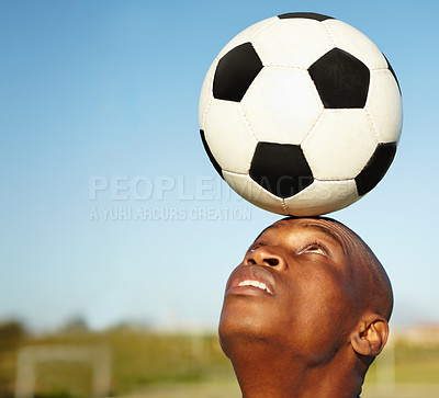 Buy stock photo A man balancing a soccer ball on his head