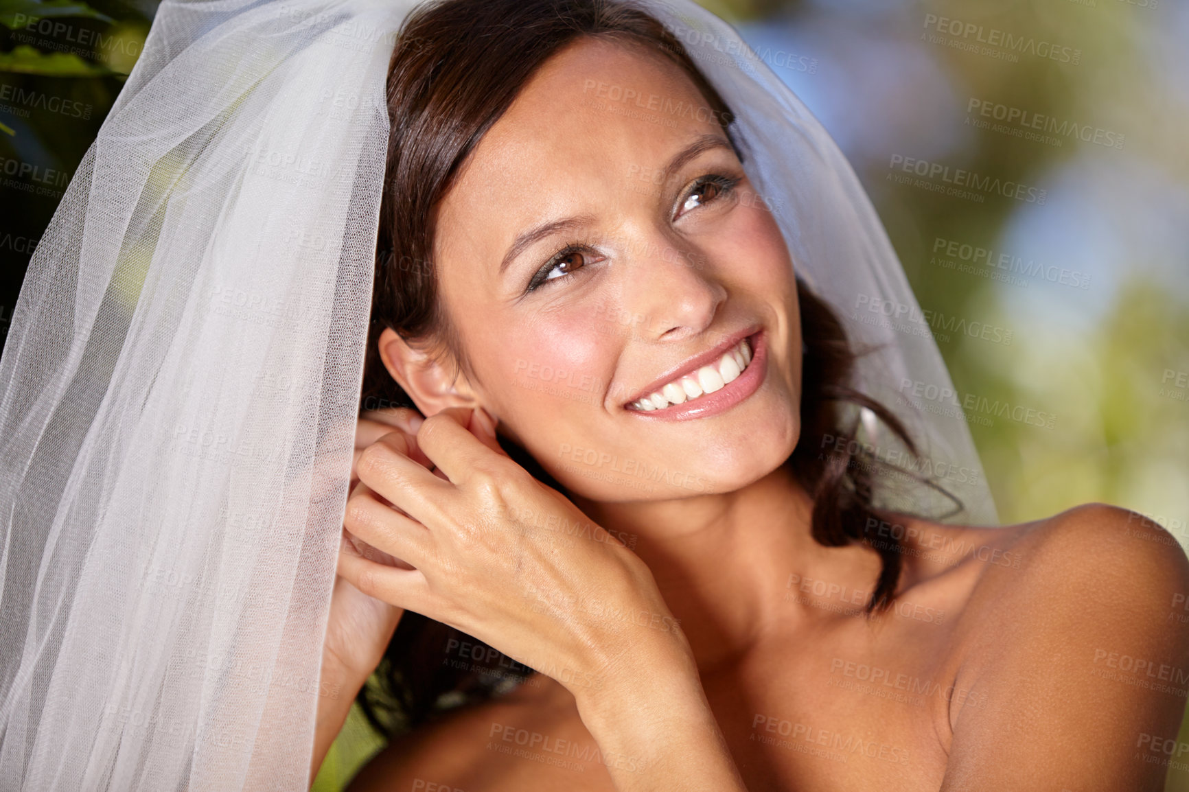 Buy stock photo Beautiful bride adjusting her earrings on her wedding day