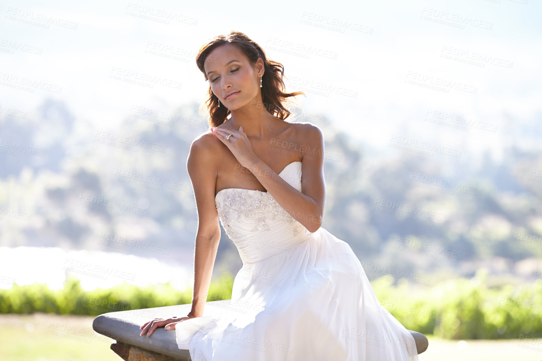 Buy stock photo Gorgeous young bride outdoors in her wedding dress