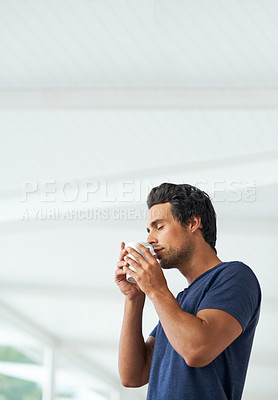 Buy stock photo Profile of a handsome young man holding a cup of coffee to his nose and enjoying the aroma- copyspace