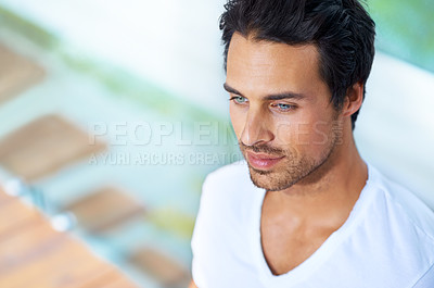 Buy stock photo A handsome young man sitting with his back agains a pane of glass