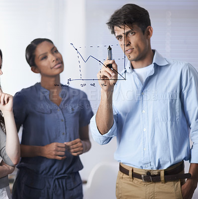Buy stock photo A handsome businessman explaining a graph of predictions on glass to an interested coworker