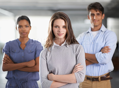 Buy stock photo A young business team standing with arms folded