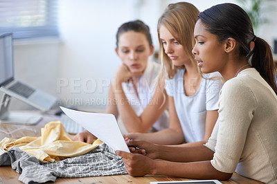 Buy stock photo Three young fashion designers discussing a design