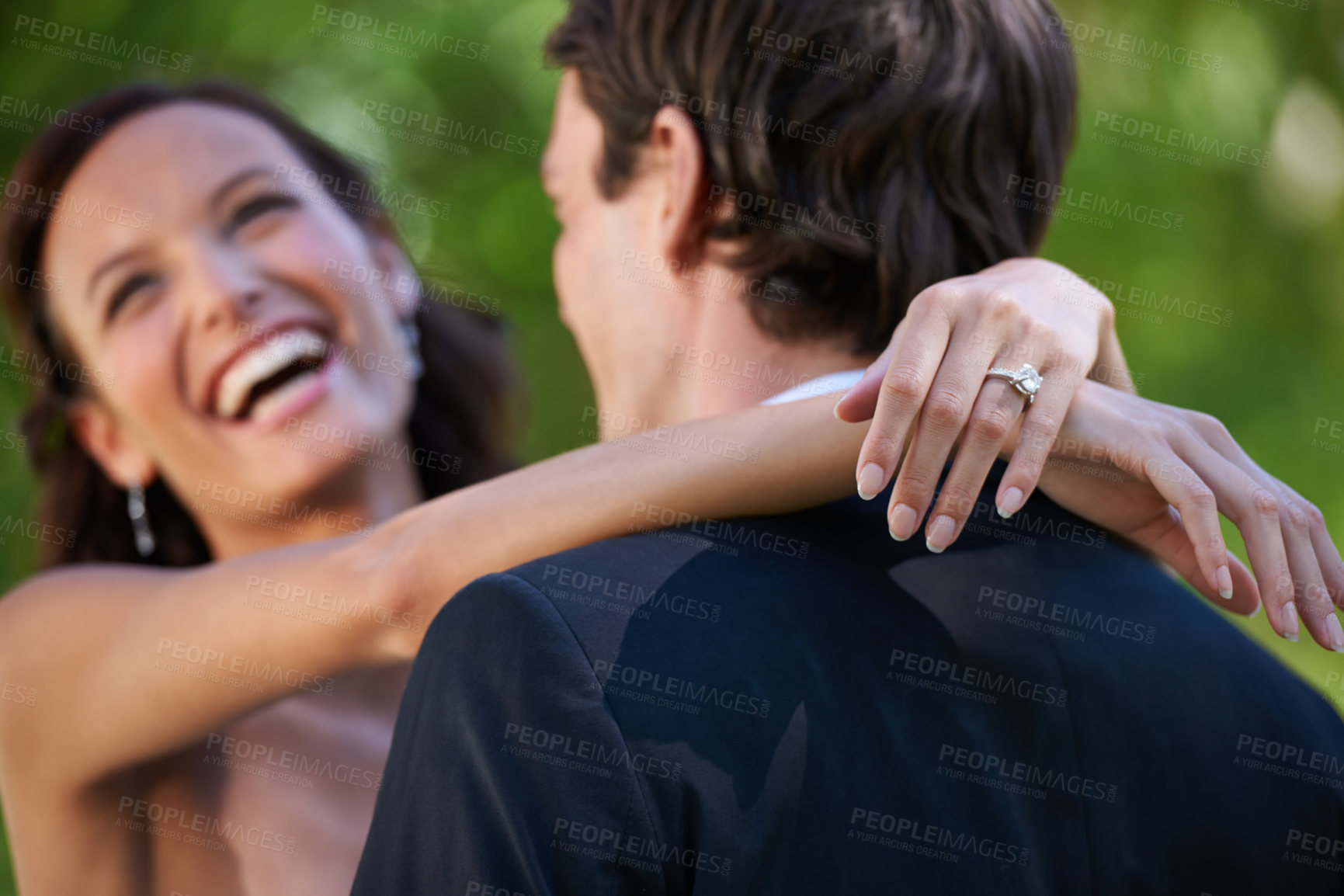 Buy stock photo A bride laughing as her new husband embraces her