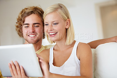 Buy stock photo Happy, tablet and young couple on sofa browsing on social media or internet at apartment. Smile, digital technology and man and woman from Australia relax and scroll on website in living room at home