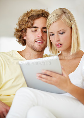 Buy stock photo Research, tablet and young couple on sofa browse on social media or internet at apartment. Happy, digital technology and man and woman from Australia relax and scroll on website in lounge at home.