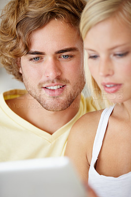 Buy stock photo Young couple, watch on laptop and relax together for home streaming service, website and movie choice on weekend. Happy man and woman reading information on computer or technology for online search 