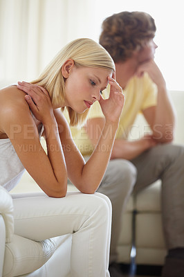 Buy stock photo A young couple reflecting on a disagreement that's just taken place