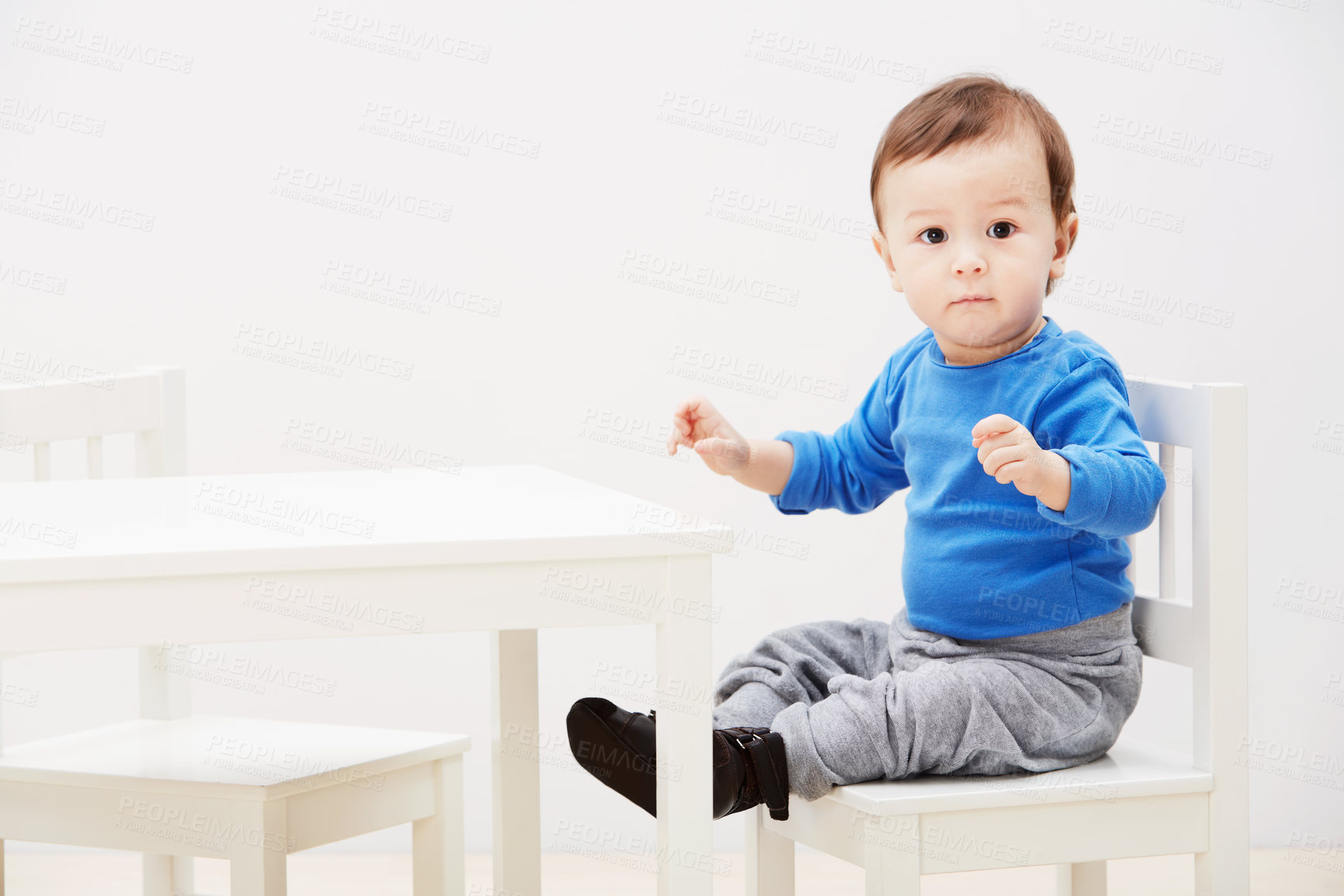 Buy stock photo Portrait of a cute baby boy sitting on a chair at a table