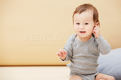 Buy stock photo Portrait of an adorable baby boy sitting on the floor and smiling at the camera