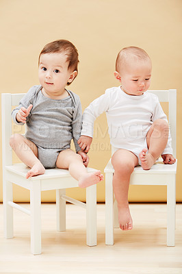 Buy stock photo Adorable portrait of two cute babies sitting on chairs and smiling at the camera