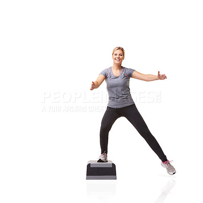 Buy stock photo A smiling young woman doing aerobics on an aerobic step against a white background - A-step
