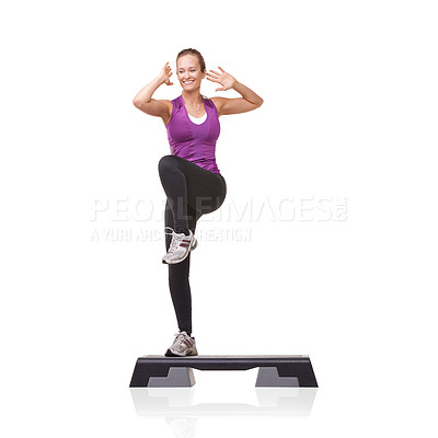 Buy stock photo A smiling young woman doing aerobics on an aerobic step against a white background