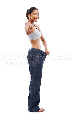 Buy stock photo Happy woman, portrait and pointing to lose weight in jeans or decision against a white studio background. Slim female person or model smile for pick or choose in health and wellness on mockup space