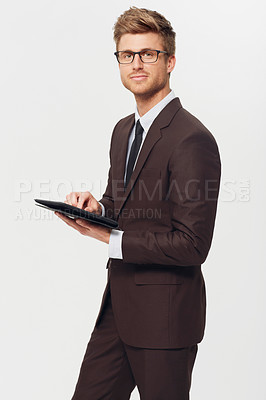 Buy stock photo Studio portrait of a stylishly-dressed young businessman holding a digital tablet