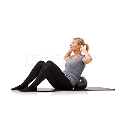 Buy stock photo A young woman doing sit-ups on an exercise ball while isolated on a white background