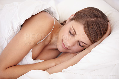 Buy stock photo A beautiful young woman wrapped up in her duvet fast asleep