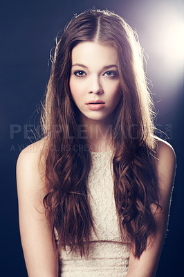 Buy stock photo A gorgeous young woman backlit with bright lights while isolated on black