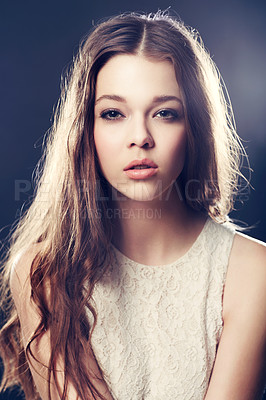 Buy stock photo A gorgeous young woman backlit with bright lights while isolated on black