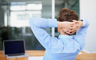 Buy stock photo A satisfied young businessman leaning back with his hands behind his head - rear view